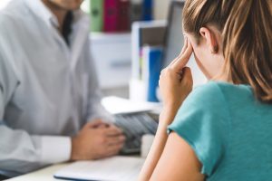 patient suffering from headaches meeting with a physician from BSSNY