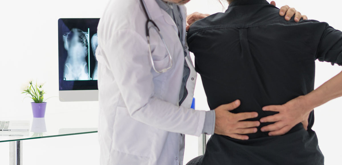 doctor examining a patient who is about to undergo a Minimally Invasive TLIF